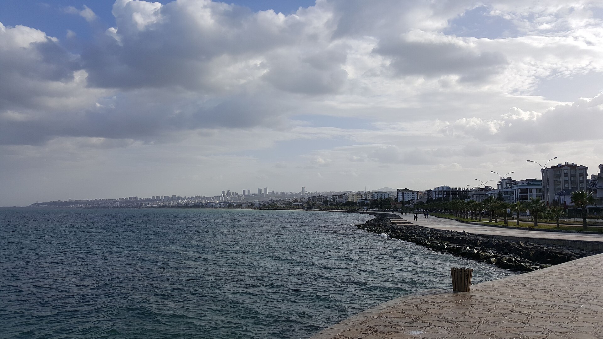 Atakum's long Black Sea waterfront promenade and Samsun skyline beneath a cloud-filled sky