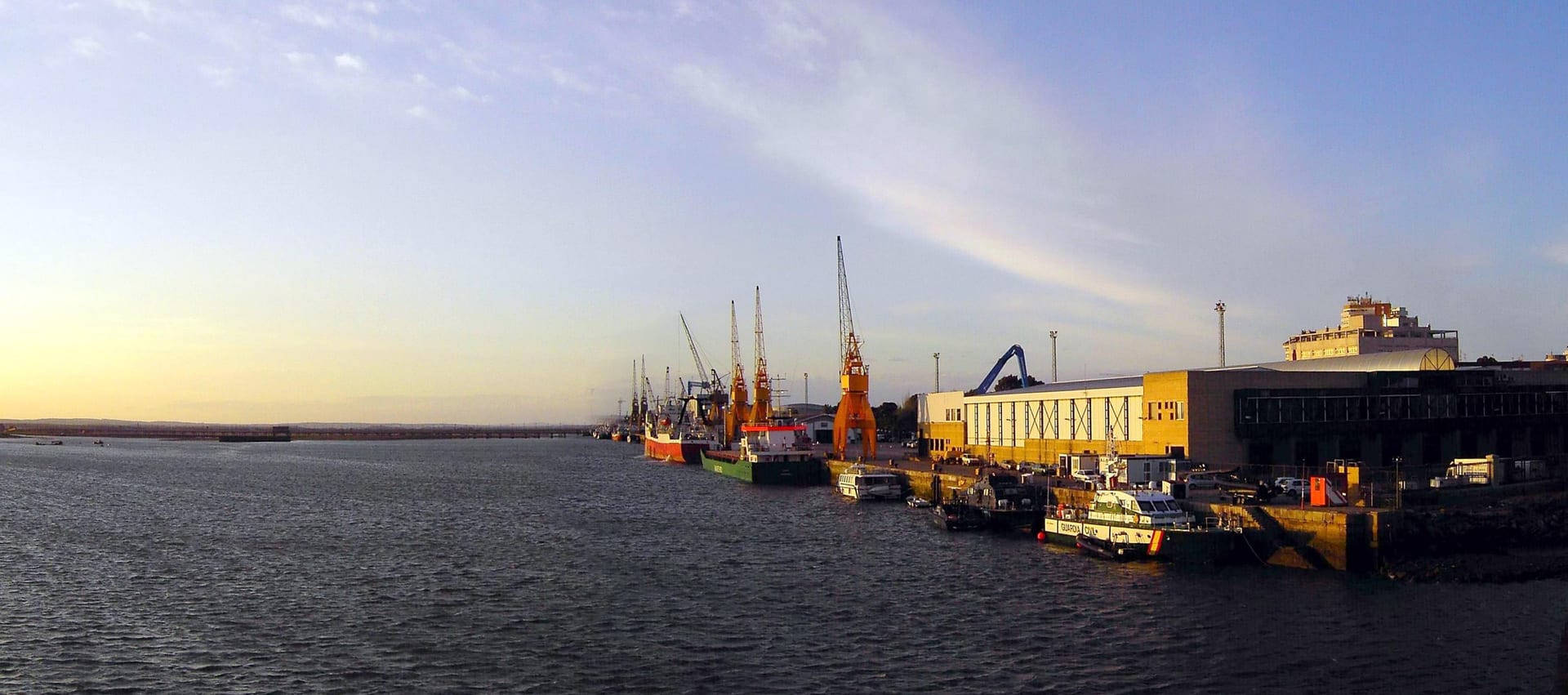 Inner Port of Huelva at sunset with working quays, vessels and cranes