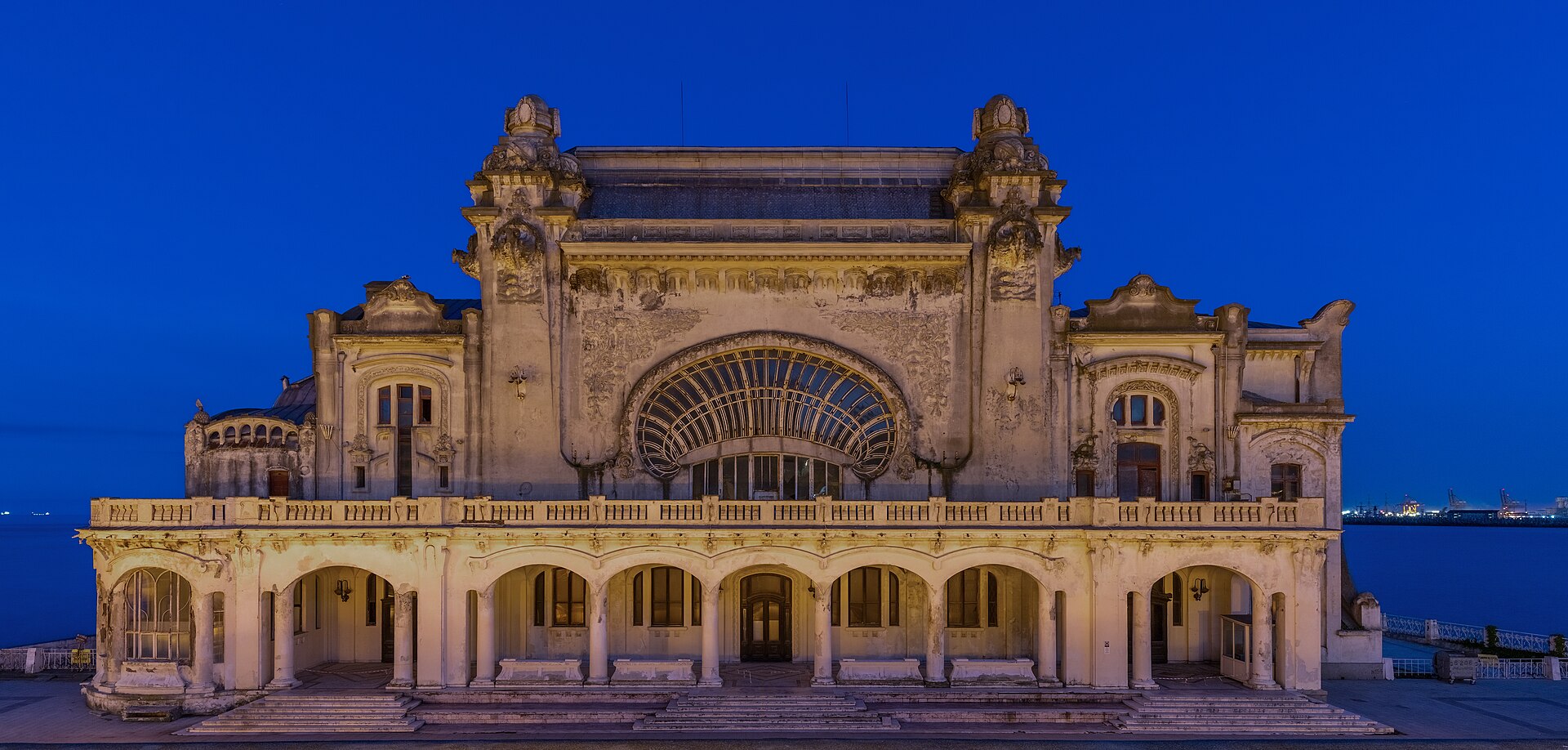 Illuminated Art Nouveau façade of Constanța Casino beside the Black Sea at blue hour