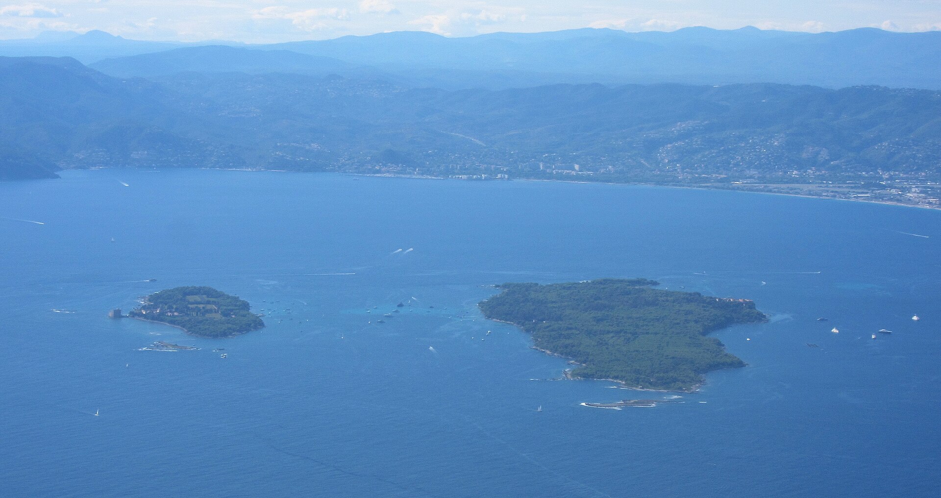 Aerial view of the green Lérins Islands in the blue Mediterranean off Cannes with the Esterel coast beyond