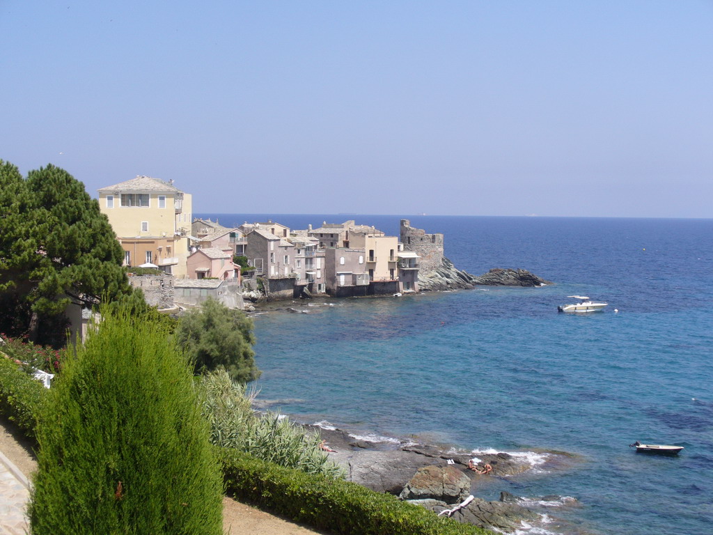 Erbalunga's stone houses, ruined Genoese coastal tower and blue sea on the eastern shore of Cap Corse