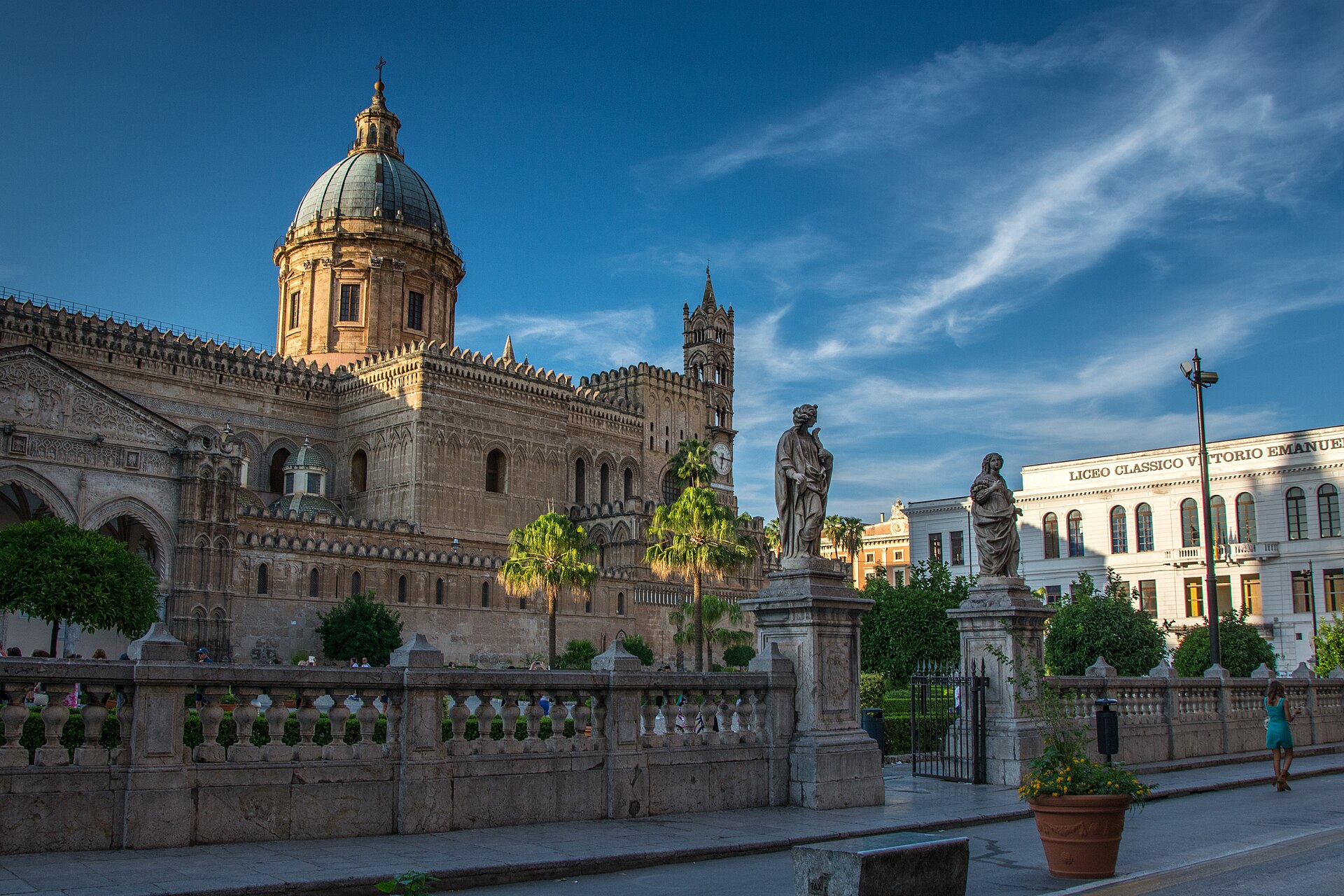 Palermo Cathedral and its palm-lined forecourt beneath a blue Sicilian sky