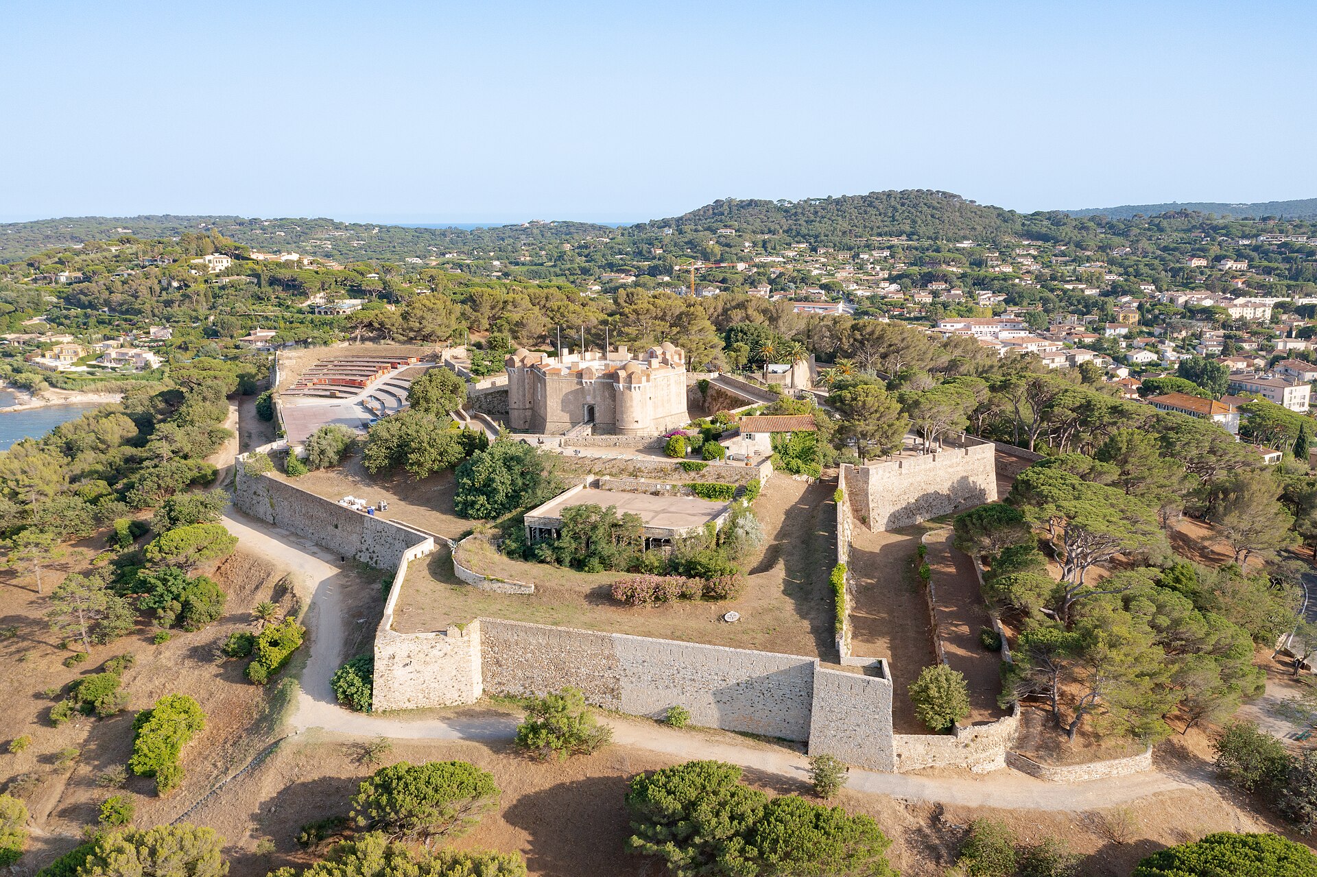Aerial view of Saint-Tropez's stone citadel and maritime museum surrounded by umbrella pines above the village and sea