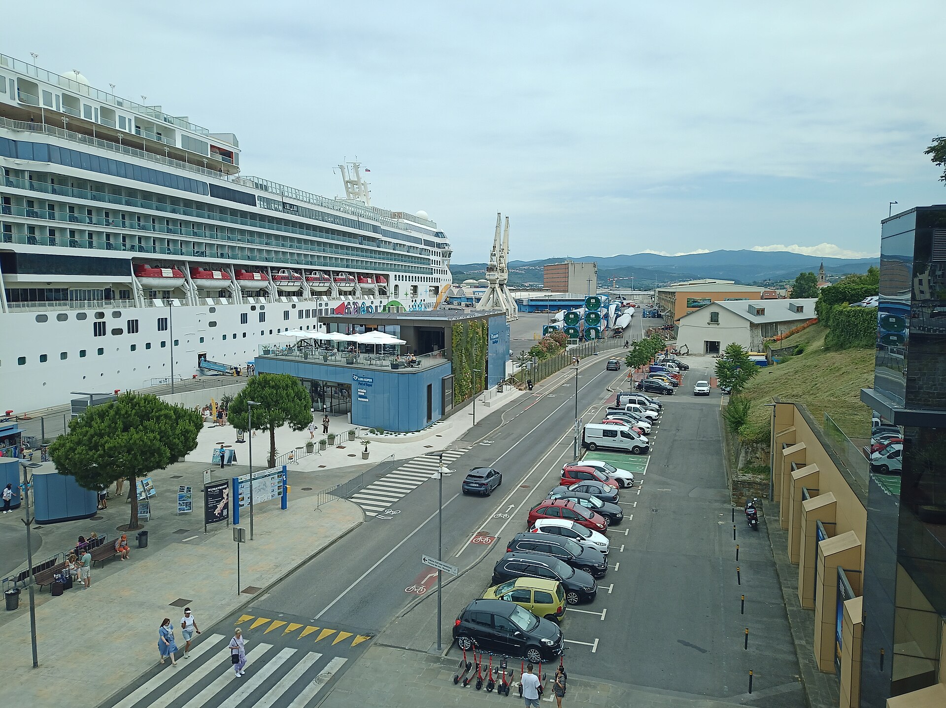 Cruise ship alongside Koper's passenger terminal with the port approach and city edge