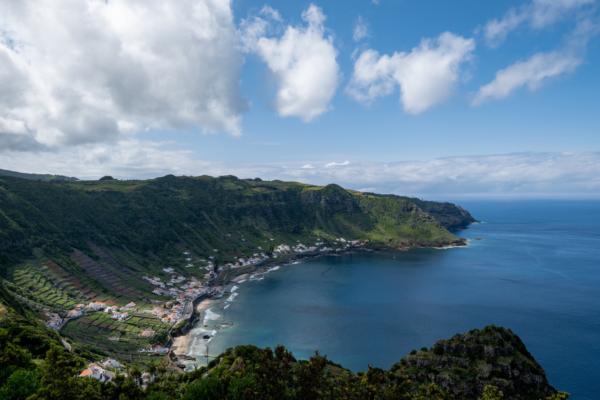 Terraced vineyards and white houses curving around São Lourenço Bay on Santa Maria in the Azores